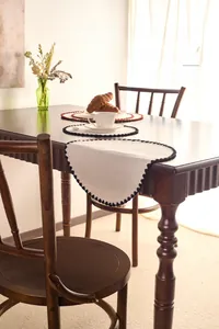 Detailed close-up of embroidered cotton linen placemat with elegant wavy scalloped edges