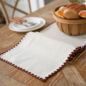Rustic cream table runner with brown wavy embroidery on wooden dining table decor