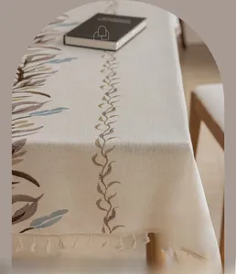 Detailed view of Nordic linen tablecloth with leaf embroidery and elegant fringe edges
