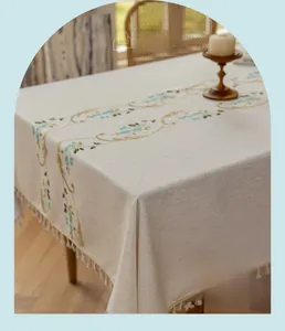 Detailed blue floral embroidery and beige tassel trim on linen rectangle tablecloth