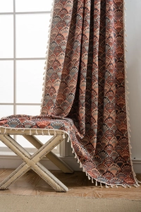 Detail eines Jacquard-Vorhangs im Boho-Stil mit Bogenmuster und cremefarbenen Quasten