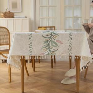 Moderne cremefarbene Tischdecke mit Blumenstickerei und Quasten für den Esstisch