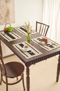 Close-up of heat-resistant woven placemats with black and white stripes and tassels