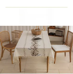 Detail of linen tablecloth featuring leaf embroidery and delicate fringe edges
