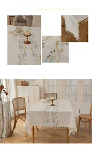 Close-up of cyan orchid embroidery and tassel fringe on beige rectangular tablecloth