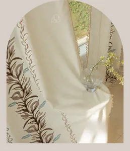 Detailed view of beige cotton linen curtain with brown leaf embroidery and tassels