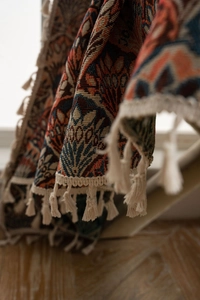 Nahaufnahme der Jacquard-Stoffstruktur mit bunten Mustern und beigen Quastenbesatz