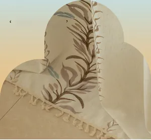 Detailed close-up of leaf embroidery and handmade tassels on beige cotton linen fabric