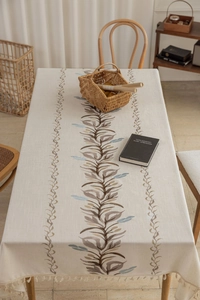 Detail of Nordic cotton linen tablecloth with leaf patterns and elegant tassel edges