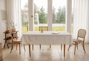 Detail of Nordic linen tablecloth featuring delicate floral embroidery and elegant tassels