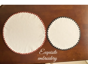 Close-up of round cotton linen placemats with exquisite scalloped embroidery edges