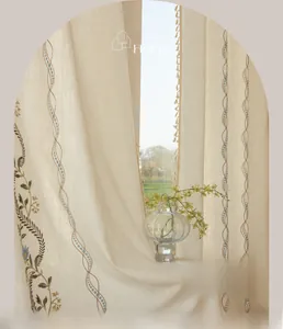 Detailed embroidery on off-white linen curtains with tassel edges and rustic floral patterns