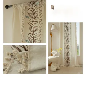 Detailed close-up of linen curtain featuring leaf embroidery and beige tassel fringe decoration