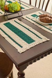 Detailed close-up of woven cotton placemats with cream and green stripes and fringe