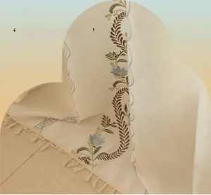 Detail of vine embroidery and fringe edge on beige cotton linen curtain fabric