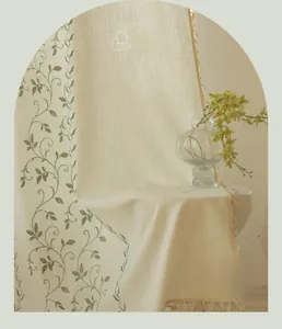 Close-up of beige linen curtain with vine embroidery and elegant tassel fringe detail