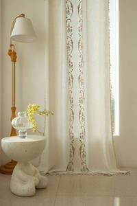Detailed embroidery of vintage floral patterns and tassel edges on beige linen curtain