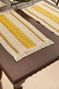 Detail of hand-woven cotton placemat with cream and mustard stripes and fringe