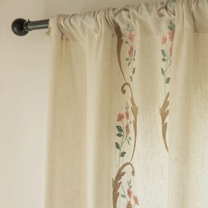 Detailed embroidery of pink flowers and green leaves on cream linen curtain