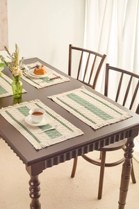 Detail of woven table runner with green stripes, diamond texture, and tassel edges