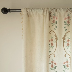 Pastoral floral embroidered linen curtain with beige fringe hanging on a black rod