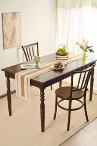 Detail of woven table runner with tassels featuring vintage cotton and linen textures