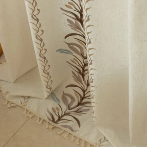 Oatmeal linen curtain with leaf embroidery and tassel fringe in a rustic country style