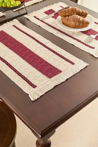 Detailed texture of woven boho table mat with fringe on a rustic wooden dining table