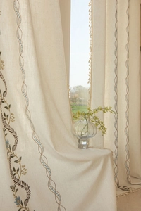 Detailed embroidery with bohemian wave patterns and blue dots on linen curtains