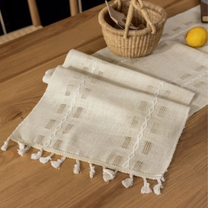 Beige hollow cotton linen table runner with tassels for a minimalist dining decor