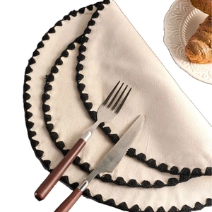 Beige cotton linen round placemat with black pom-pom trim for rustic table setting