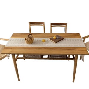 Modern solid wood dining table with minimalist linen table runner and tassel accent