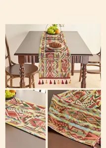 Close-up of red jacquard table runner with geometric patterns and tassel fringe detail