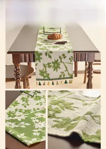 Detail of green rose jacquard table runner with decorative tassels on wooden table