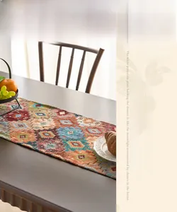 Detail of woven table runner featuring orange geometric patterns and delicate tassels