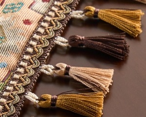 Macro view of geometric ethnic table runner with decorative silk tassels and embroidery