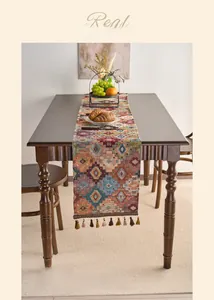 Detail of bohemian geometric pattern woven table runner with dark brown tassels