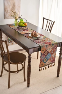 Detailed texture of ethnic woven table runner with orange geometric patterns and tassels