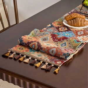 Ethnic bohemian table runner with orange geometric patterns and colorful tassels