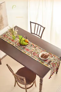 Close-up of ethnic geometric jacquard table runner with colorful handmade tassels