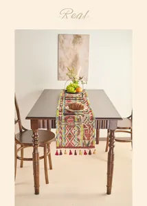 Close-up of bohemian table runner with colorful geometric patterns and tassel details