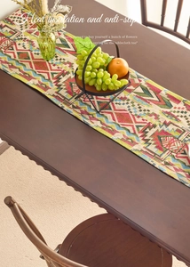 Detail of bohemian table runner with colorful geometric patterns on a wooden table