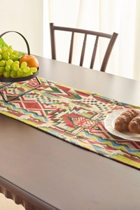 Detail of bohemian geometric table runner with colorful woven patterns on a wood table