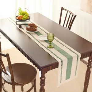 Detailed texture of cotton linen table runner with green stripes and handmade tassels