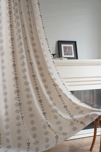 Close-up of Nordic floral pattern on cream linen curtains with elegant texture