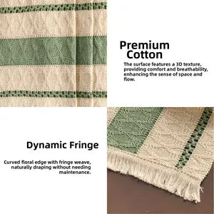 Detail of green and white woven table runner with cotton texture and tassel fringe
