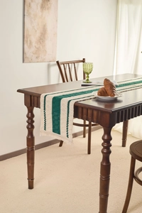 Close-up of retro dark green and beige striped table runner with decorative tassels