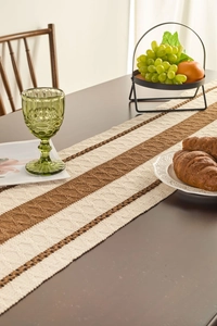 Close-up detail of Nordic striped table runner with diamond knit texture and tassels