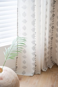 Detailed texture of off-white linen curtain with black Nordic floral and geometric print
