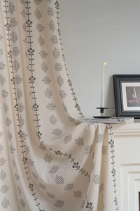 Detail of Nordic floral print curtain on beige linen fabric by white fireplace